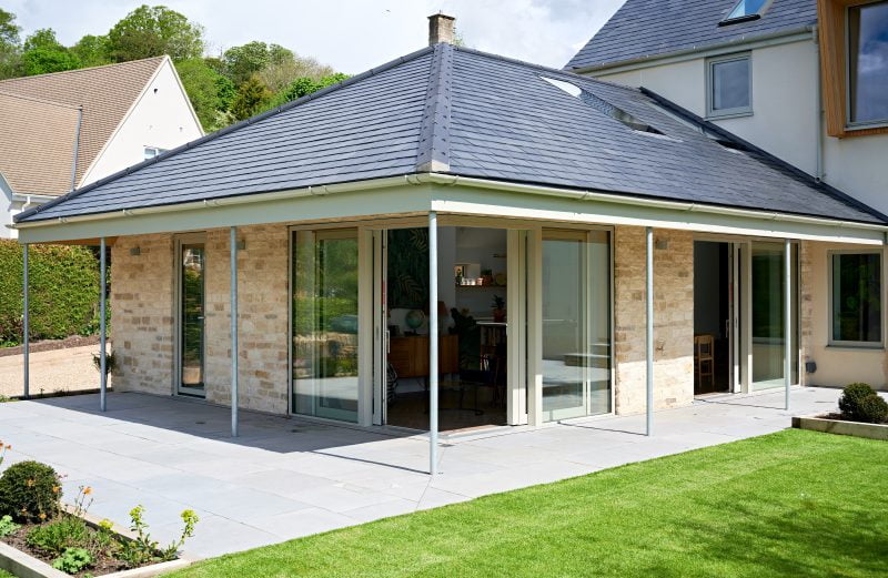 A renovated house extension with a stone brick exterior and bespoke sliding windows and doors.