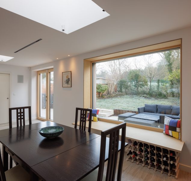 A light and airy dining room with a large triple glazed window and a patio door.