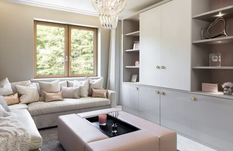 A contemporary living room with a corner sofa, coffee table and large windows letting in natural light.